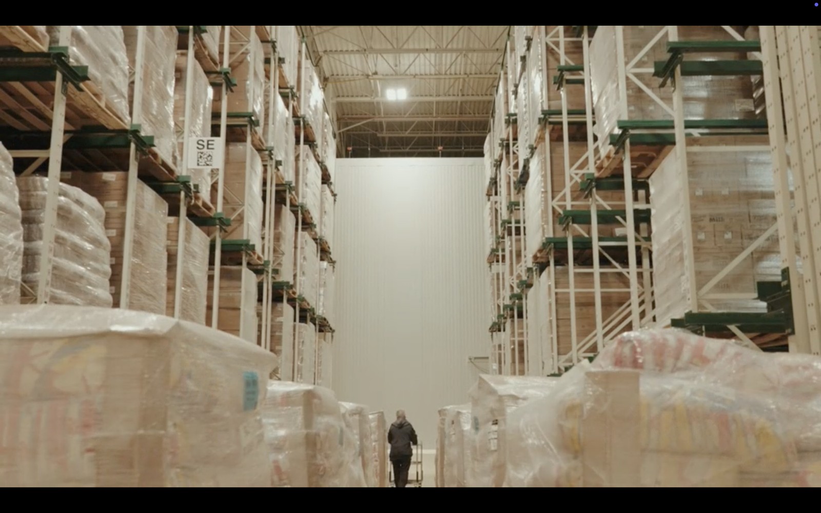A person between rows of indoor growing racks