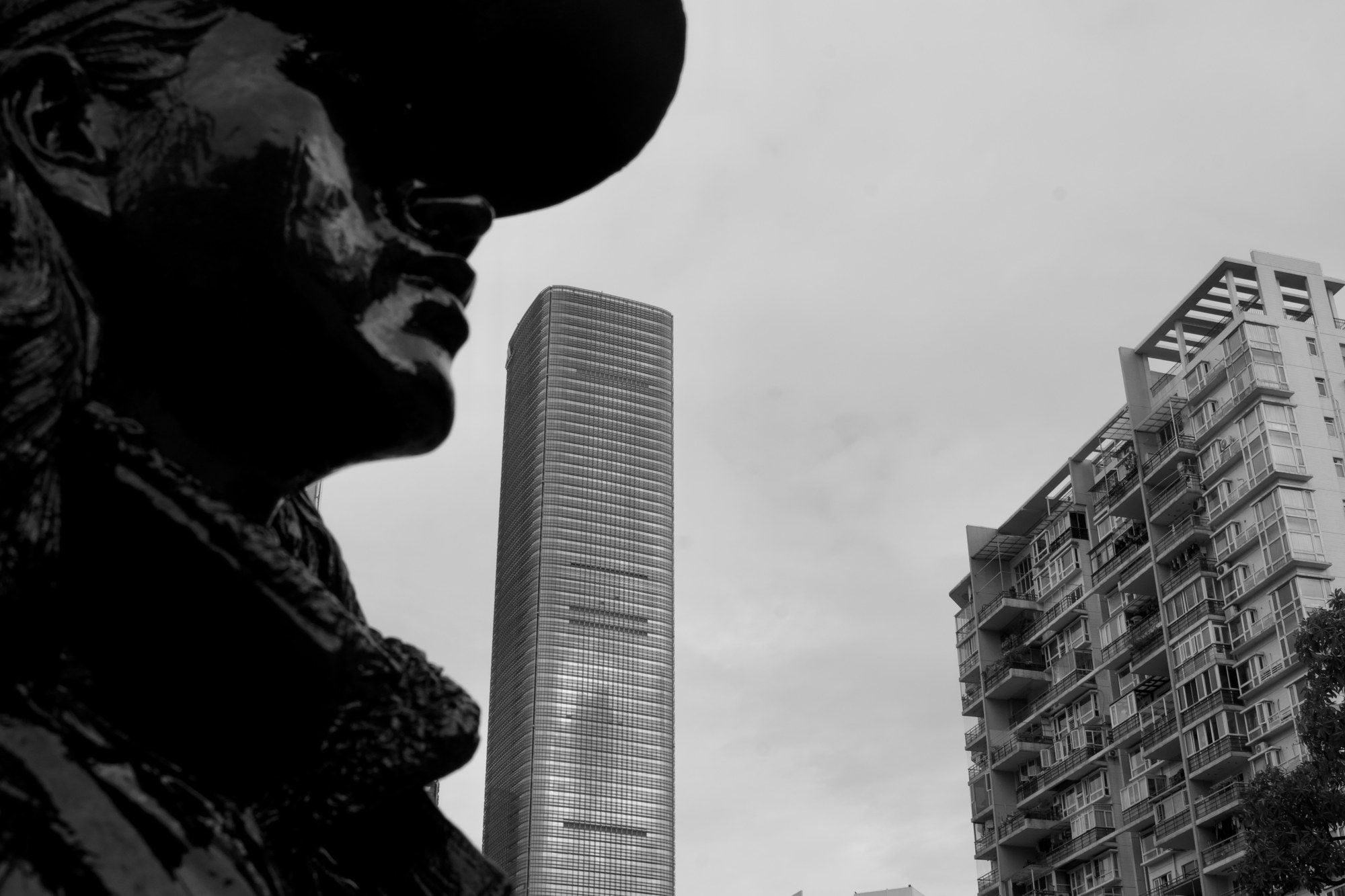 A sculpted figure against city buildings