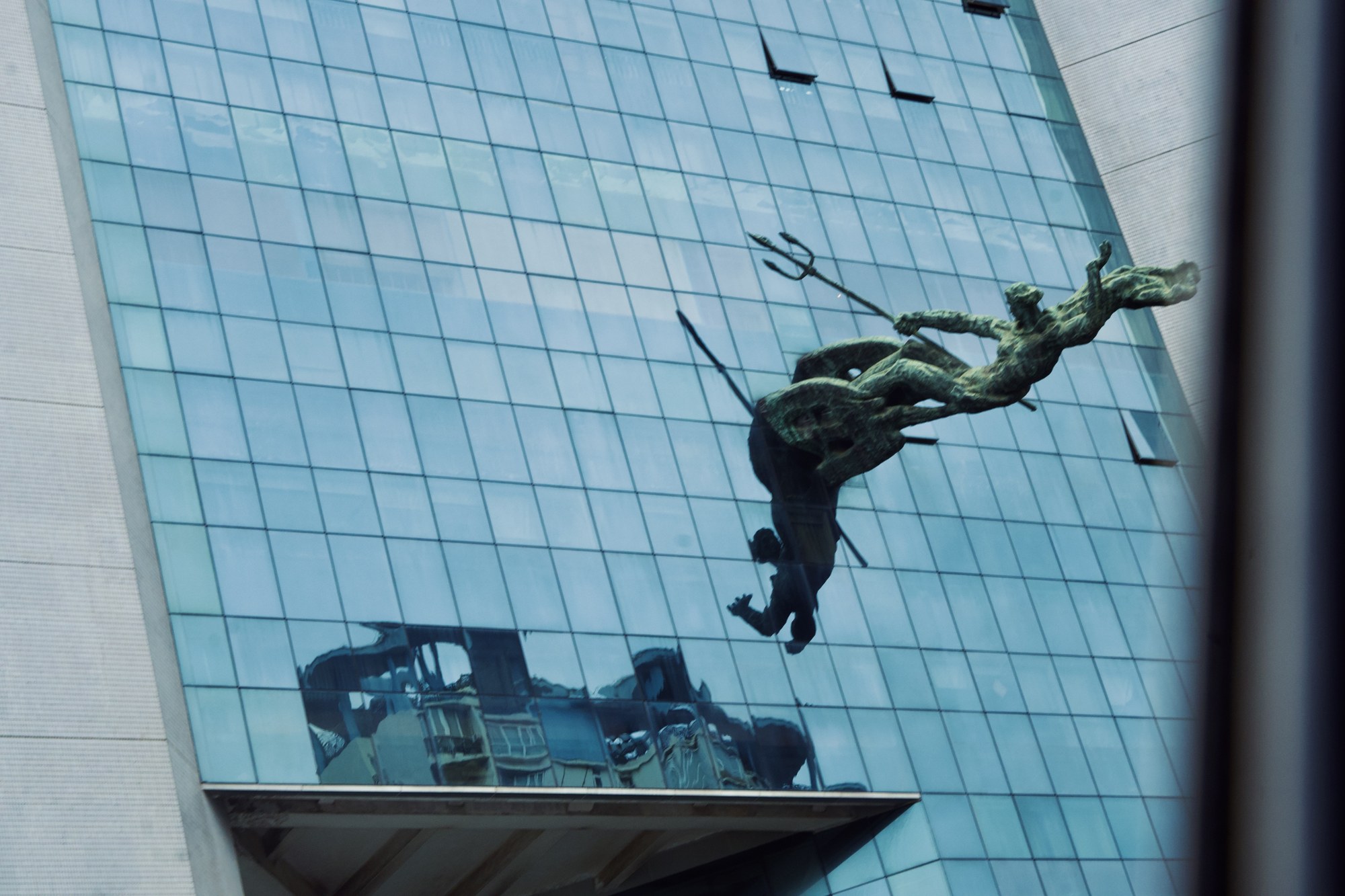 A sculpture against glass architecture
