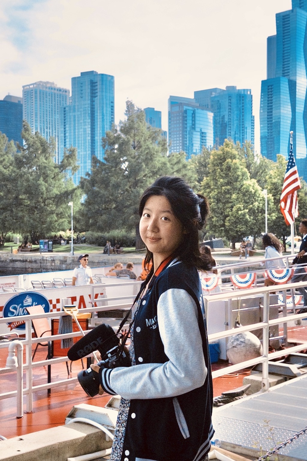 Ruixin Zhang holding a video camera on a boat in Chicago.