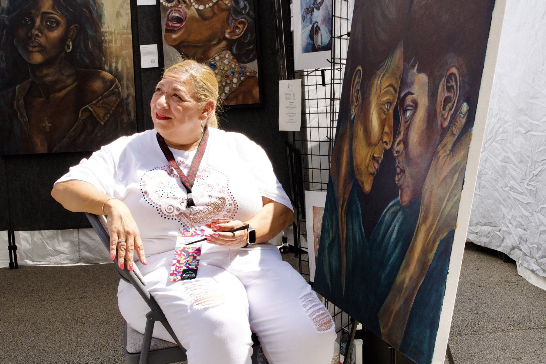 Cindy Wright-Smith, who was working on a portraiture piece by her stall, pauses to talk with a curious festival attendee.