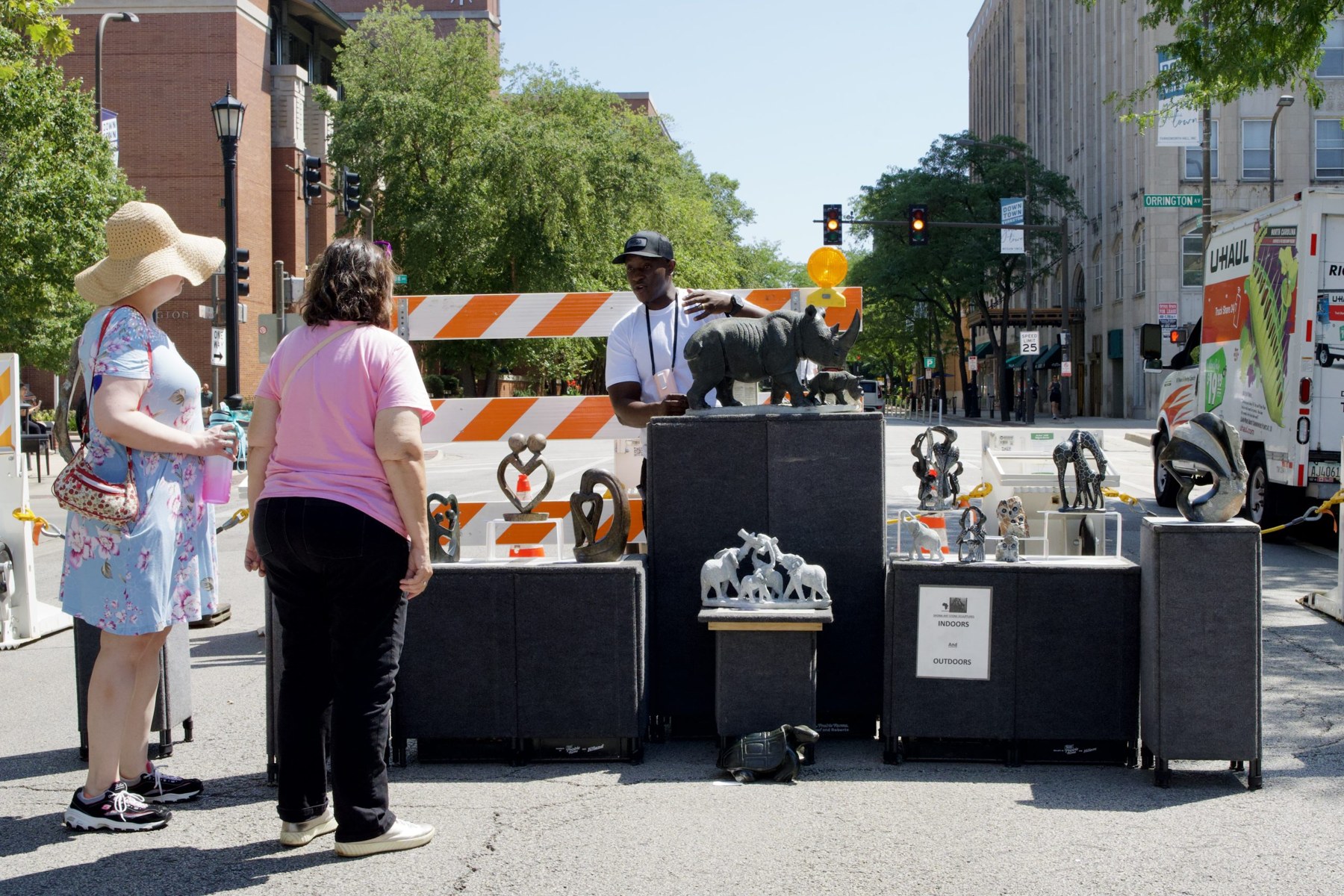 Passersby check out Peter Rujawa’s stone sculptures made out of serpentine stone. All are tribal art named after his Shona tribe of Zimbabwe.