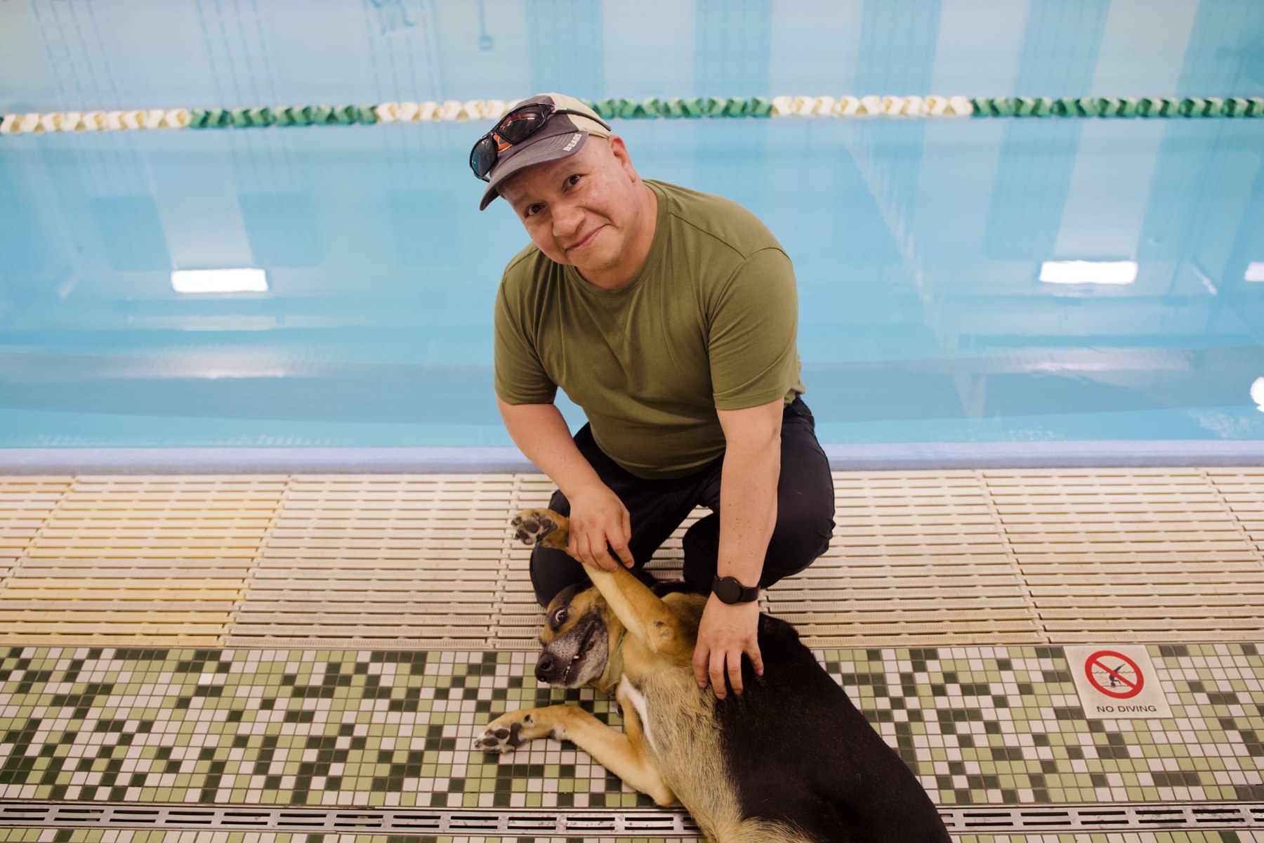 Swim coach Carlos Ceja with his dog, Frankie. Frankie serves as an unofficial mascot of Flying Fish.