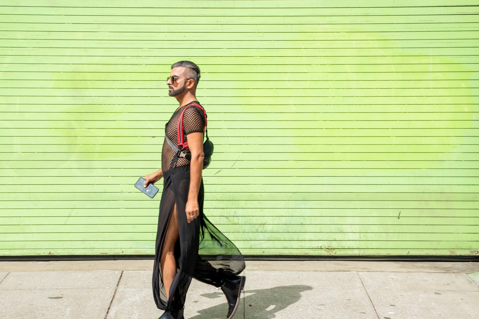 A fairgoer walks past a bright green wall at the 43rd annual Folsom Street Fair in San Francisco on Sept. 27, 2026.