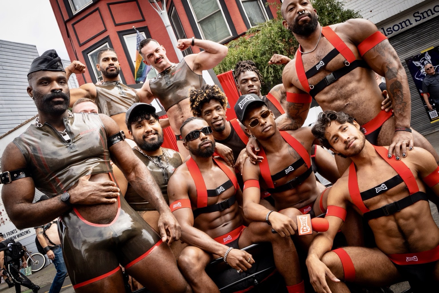 Fairgoers wearing red-and-black harnesses pose for a group portrait at the 43rd annual Folsom Street Fair in San Francisco on Sept. 27, 2026.