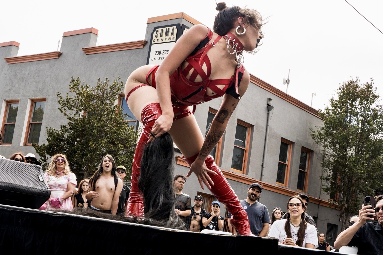 A performer wearing red boots leans toward spectators at the 43rd annual Folsom Street Fair in San Francisco on Sept. 27, 2026.