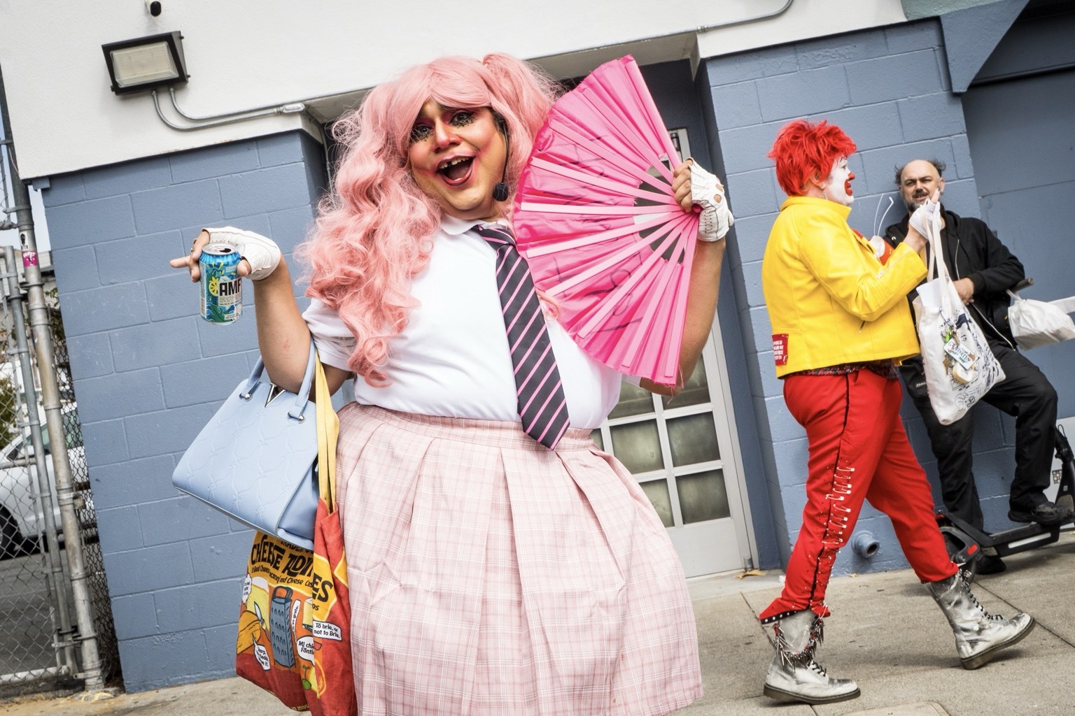 A fairgoer wearing a pink wig poses with a matching fan at the 43rd annual Folsom Street Fair in San Francisco on Sept. 27, 2026.