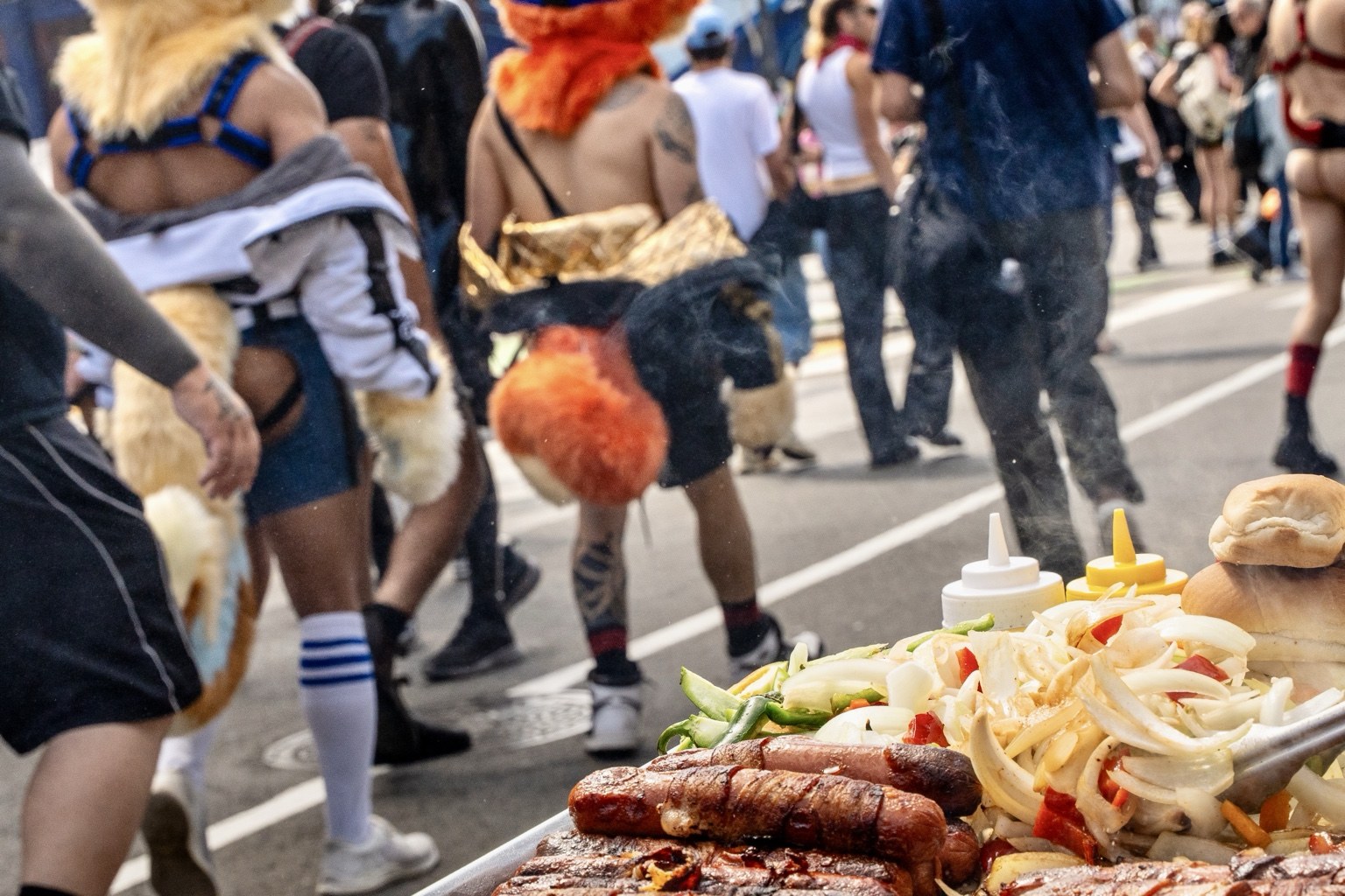 Food cooks on a vendor’s grill as fairgoers pass by at the 43rd annual Folsom Street Fair in San Francisco on Sept. 27, 2026.