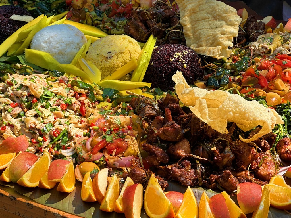 The community shares the “Green-leaf Banquet” that everyone spent the morning preparing together. Dishes with different potherbs–wild lemongrass pork chops, “Ghost Chicken”, century egg salad–are placed upon banana leaves. The banquet shows Jingpo people’s gratitude to nature.