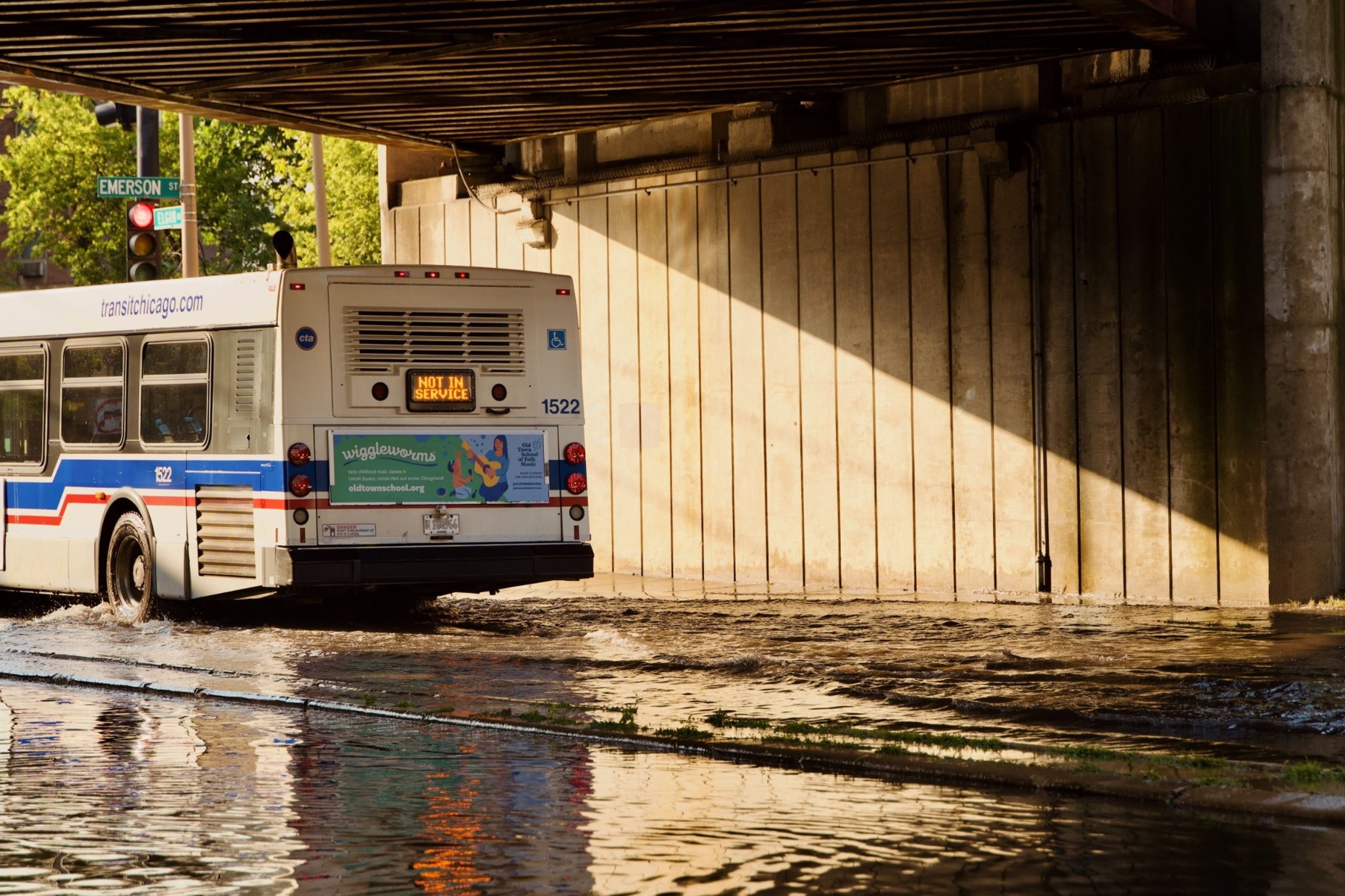 An out-of-service bus drives under an overpass near Emerson Street and Elgin Road.