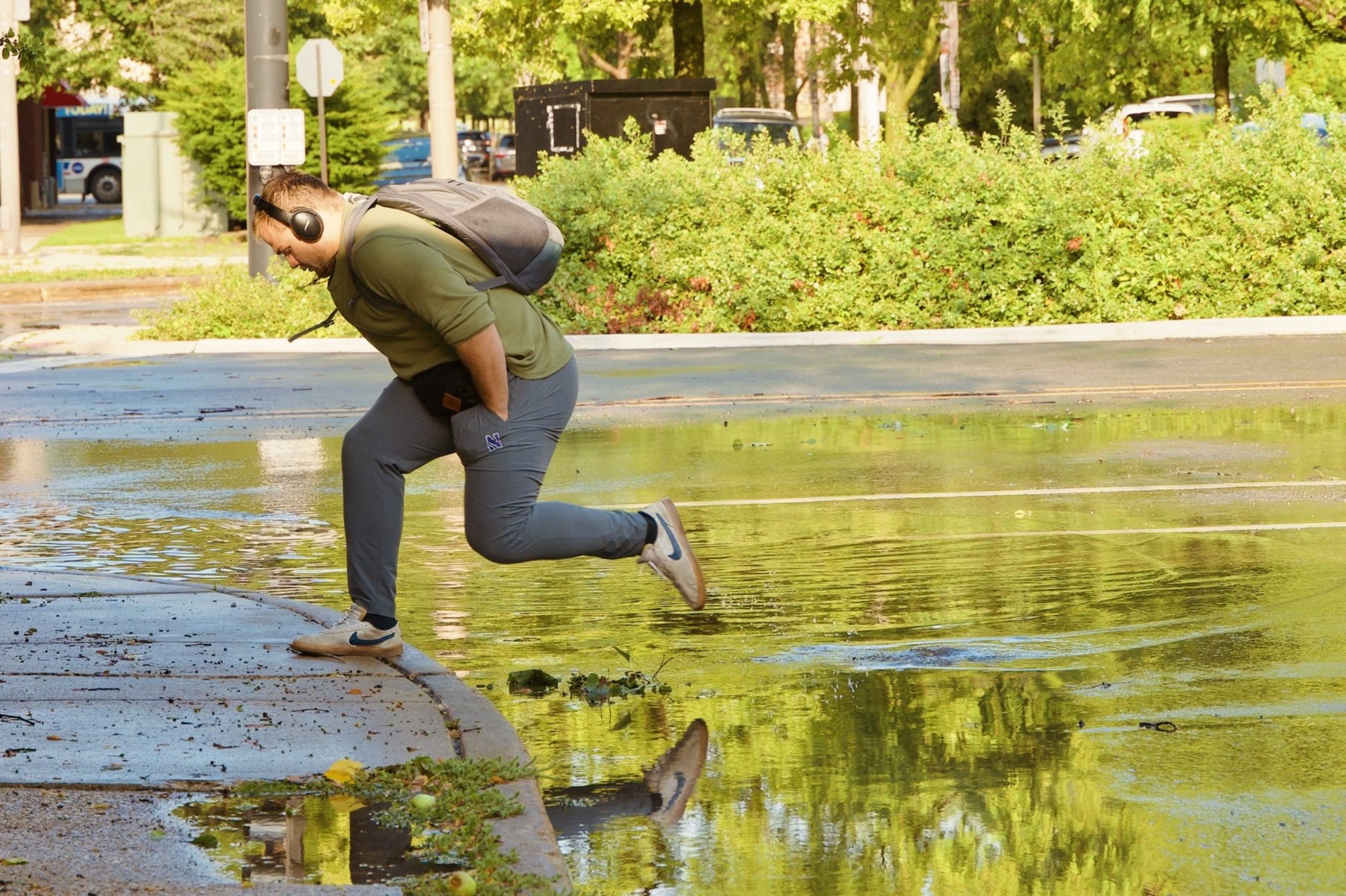 Jumping onto the sidewalk to avoid a big puddle.
