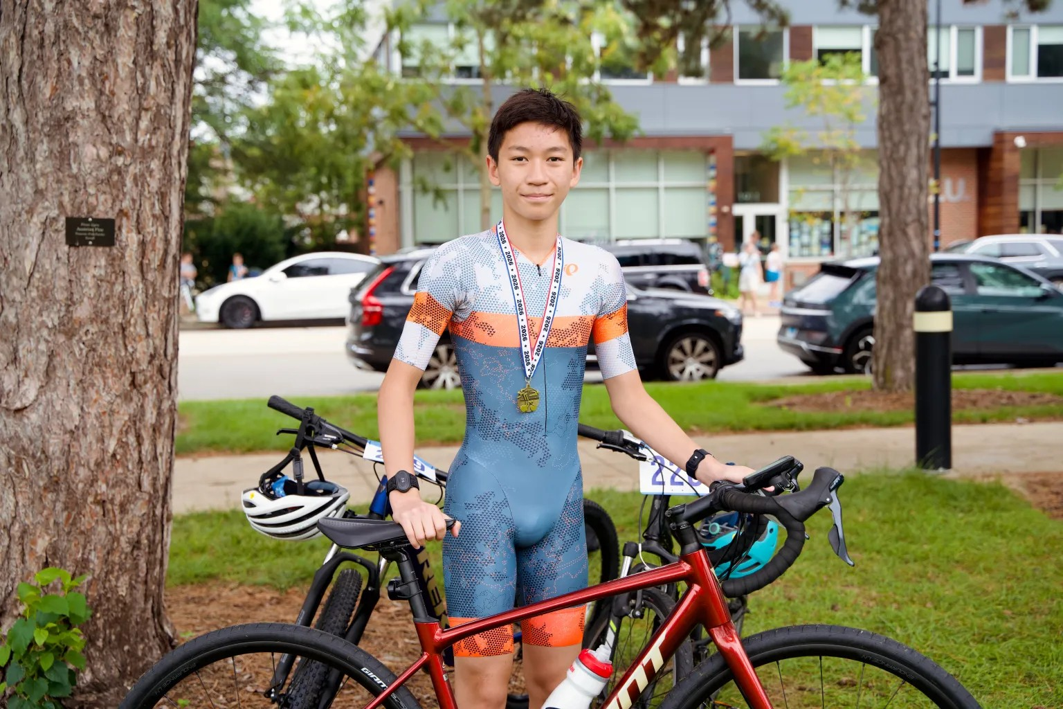 A cyclist poses beside a bicycle.