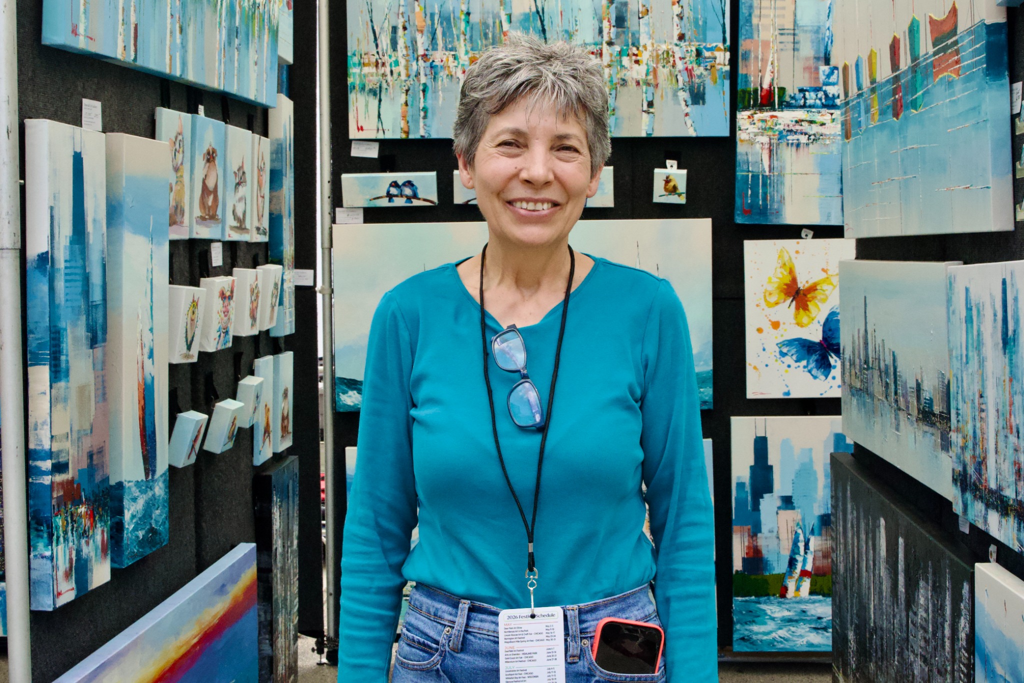 An artist poses among displayed artwork.