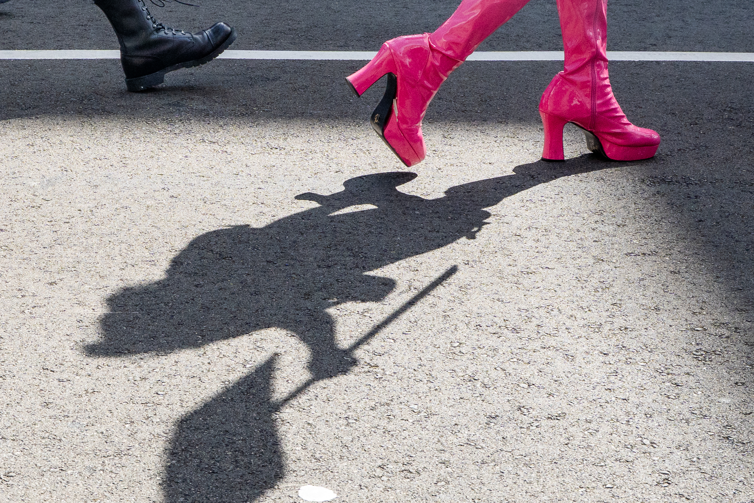 A fairgoer’s pink platform boots cast a shadow on the pavement at the 43rd annual Folsom Street Fair in San Francisco on Sept. 27, 2026.