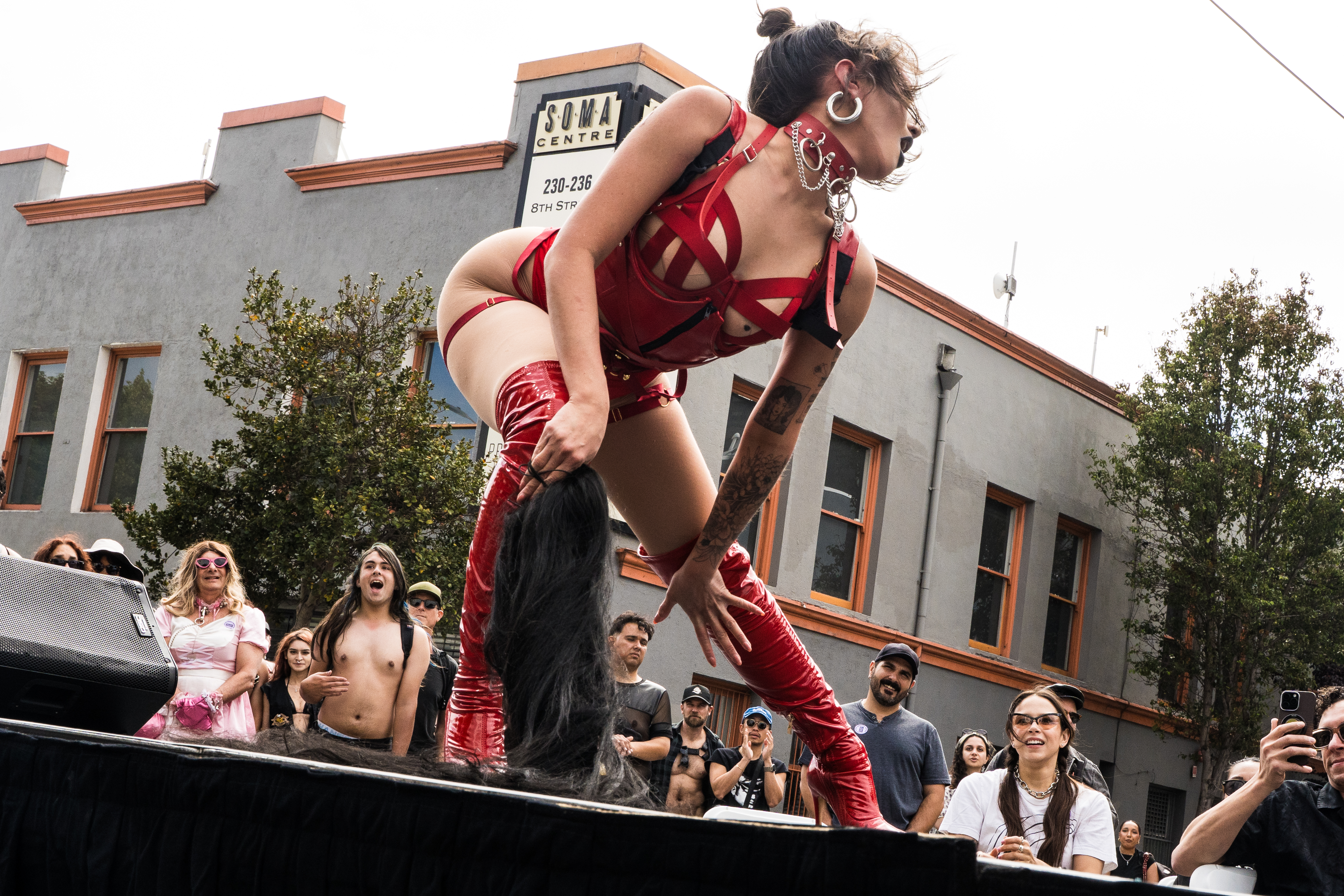 A performer wearing red boots leans toward spectators at the 43rd annual Folsom Street Fair in San Francisco on Sept. 27, 2026.